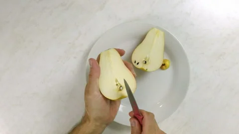 Cutting pears in half and removing cores of pears Stock Footage 100232129
