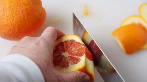 Cutting peel and pith from orange Stock Footage 104784475