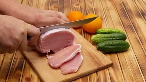 Cutting a piece of fresh meat, cutting meat in the kitchen. Next to the meat are Stock Footage 202299313
