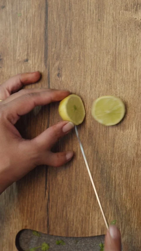 Cutting a piece of lemon on chopping board, lemon chopped on a chopping board. Stock Footage 283363283