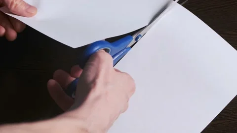Cutting a piece of paper in a half with scissors Stock Footage 156634568