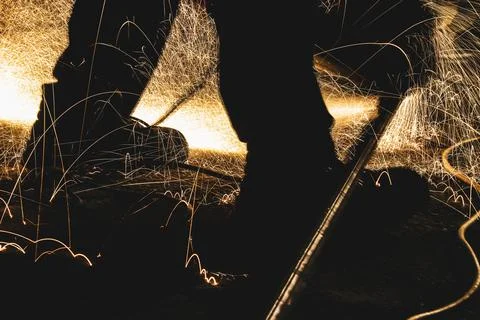 Cutting a piece of pipe that the man keeps on his leg Stock Photos