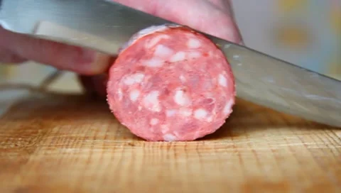 Cutting a piece of sausage. Video stock 8989878