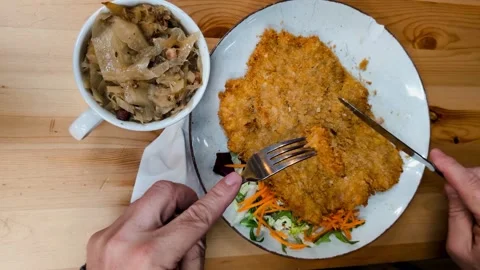 Cutting off a piece of Schabowy breaded fried pork cutlet Stock Footage 304854571