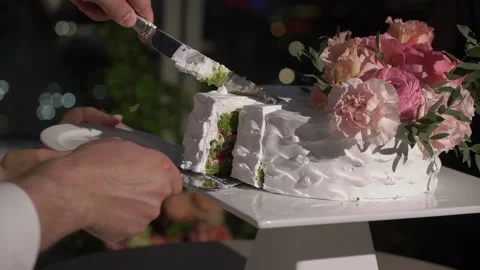 Cutting piece of wedding cake. Bride and groom with knife at reception. Stock Footage 166587571