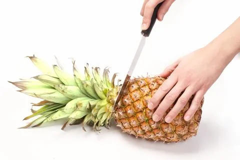 Cutting pineapple with knife on white background Stock Photos