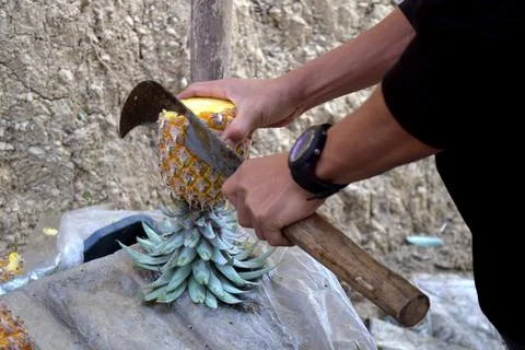 Cutting the pineapple with a sharp knife Stockfoto's