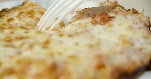 Cutting pizza with a fork and a disposable plastic knife Stock Footage 92163197