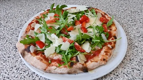 Cutting the pizza Rucola with cherry tomatoes cheese,Italian food,Restaurant Stock Footage 116046488