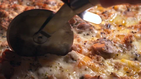 Cutting a pizza using a pizza cutter Video stock 305958102