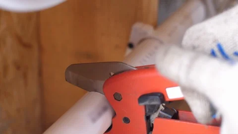 Cutting plastic pipe with special scissors. 4k slow motion. Plumbing work in the Stock Footage 96582623