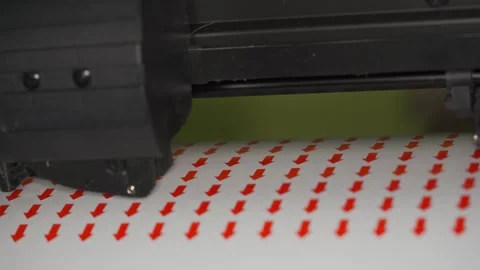 Cutting plotter machine making small round red arrows stickers, closeup detai Stock Footage 295813357