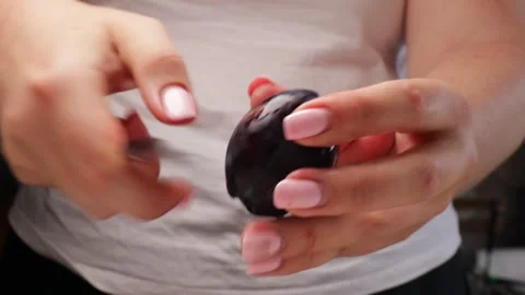 Cutting plum in half and removing pit. Close-up of female hands using knife to Stock Footage 317106728