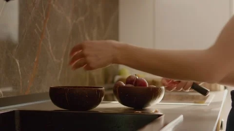 Cutting plums and preparing fruit for a fresh and healthy snack in the kitchen Stock Footage 320951869