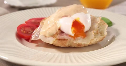 Cutting poached egg with bacon on a plate. boiled egg on bread with sauce. Stock Footage 241082348