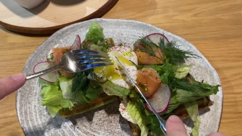 Cutting poached egg with runny egg yolk over bread toast Stock Footage 257062070