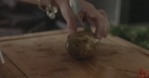 Cutting a potato on a chopping board Stock Footage 76412830