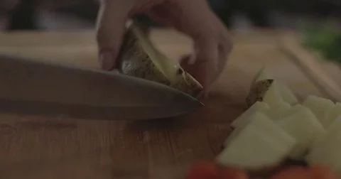 Cutting a potato on a chopping board Video stock 76412885