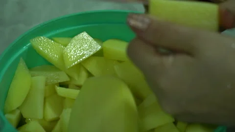 Cutting potatoes with a knife at home in the kitchen without gloves Stock Footage 258131801