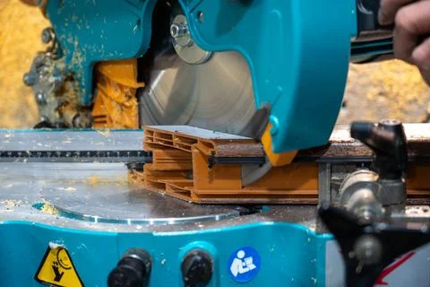 Cutting PVC window frame profile with electric miter saw in fabrication workshop Stock Photos