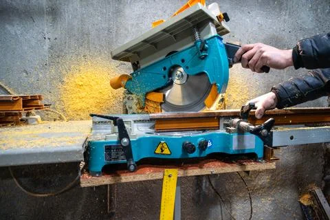 Cutting PVC window frame profile with electric miter saw in fabrication workshop Stock Photos