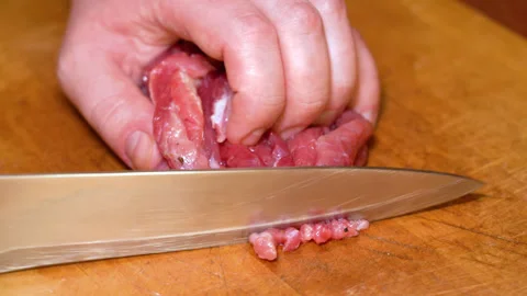 Cutting raw beef on a cutting board closeup Stock Footage 250085716