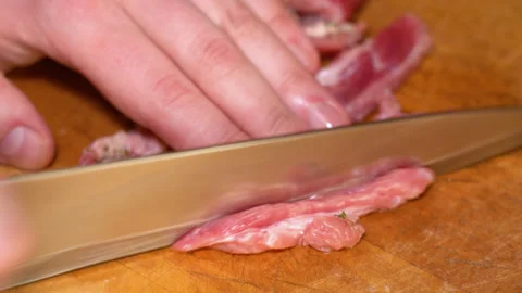 Cutting raw beef on a cutting board closeup Stock Footage 250085717