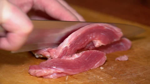 Cutting raw beef on a cutting board closeup Stock Footage 250086273