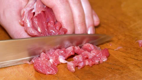 Cutting raw beef on a cutting board closeup Stock Footage 250086297