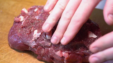 Cutting raw beef on a cutting board closeup Stockbeeldmateriaal 250551088