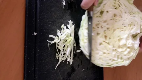 Cutting raw Cabbage on plastic board recipe Stock Footage 143087063