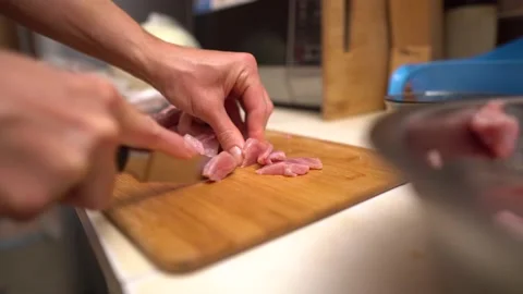 Cutting raw meat. Cook cutting raw meat on wooden board with knife. Stock Footage 144390988