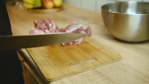 Cutting raw meat into equal portions on wooden board Stock Footage 340078033