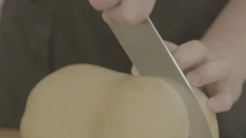 Cutting raw pumpkin slice. Man cutting an orange pumpkin piece. Stock Footage 90233212