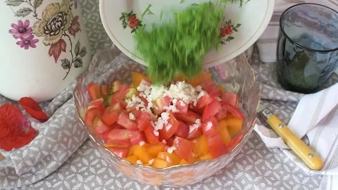 Cutting red and yellow tomatoes along with young garlic. Mixing these ingre.. Stock-Footage 337720245
