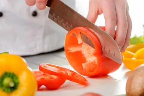 Cutting a red bell pepper into ring slices Stock Photos