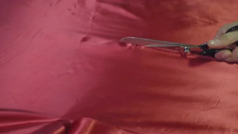 Cutting red fabric using large scissors slow motion Stock Footage 154052233