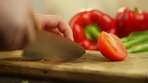Cutting a red ripe tomato with a poorly sharpened knife. Stock Footage 296363658