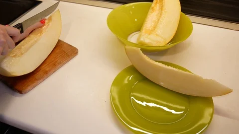Cutting up a ripe melon on a kitchen countertop Stock Footage 113742724