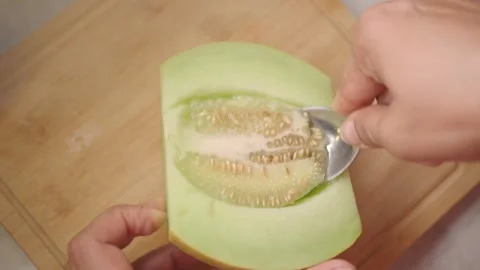 Cutting a ripe melon in a kitchen setting during daytime Stock Footage 337752883