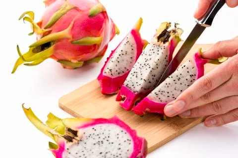 Cutting off a second fruit chip from a pitaya half Stock Photos