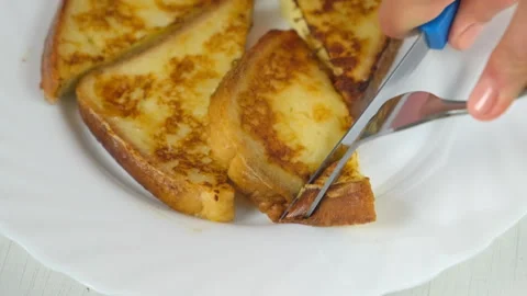 Cutting served fried toasts bread slices on plate on kitchen at home. Stock-Footage 313134609