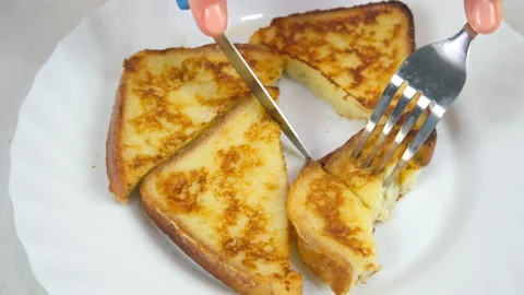 Cutting served fried toasts bread slices on plate to eat on kitchen at home. Video stock 313134939