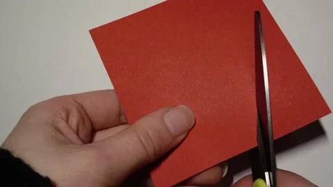 Cutting a shape out of a red piece of paper Stock Footage 231914438