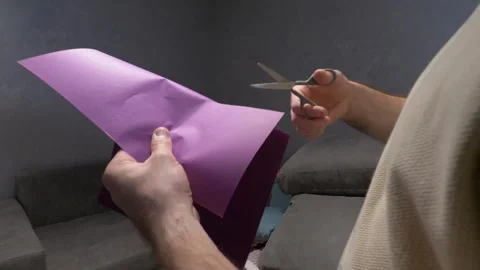 Cutting sheet of colored paper with scissors. Person cutting strips out of paper Vídeos de archivo 340209155