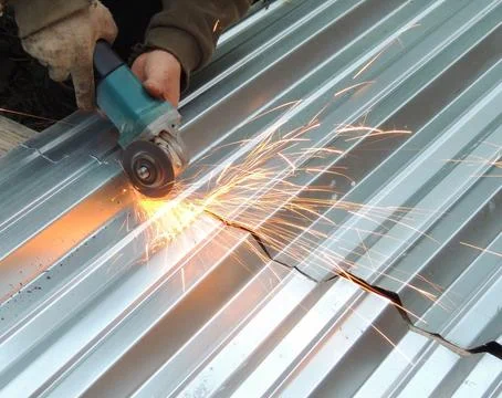 Cutting sheet iron with a grinder Stock Photos