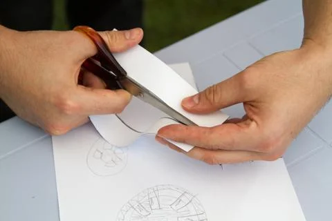 Cutting a sheet  paper using metallic scissors Stock Photos