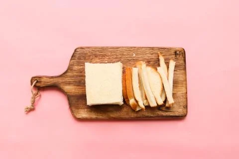 Cutting a slice of bread into a long shaped on a wood cutting board Stock Photos