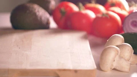 Cutting slice of bread for sandwich on a table full of vegtables. Stock Footage 138404112