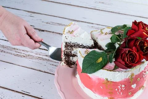 Cutting a slice of chocolate cake topped with Swiss meringue buttercream. Thr Stock Photos